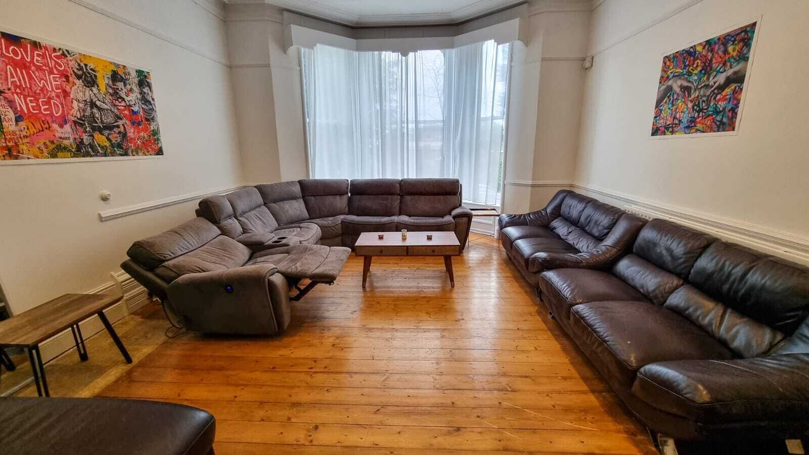 A living room with a sectional sofa, a leather couch, and a coffee table.