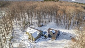 Un paisaje nevado con una casa rodeada de árboles.