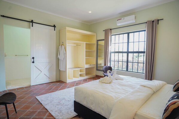 Een slaapkamer met een bed, een kledingkast, een stoel en een raam.