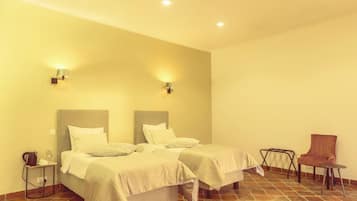Una habitación de hotel con dos camas, una silla y una mesita.