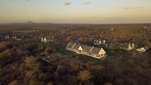 A large estate with multiple buildings, including a prominent house with a large porch and several smaller structures. - Kili Seasons Hotel (Arusha)