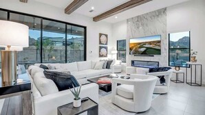 Un salon moderne avec un canapé blanc, une table basse et une cheminée.