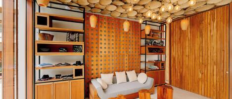 Ein modernes Wohnzimmer mit einem Holzsofa, eingebauten Regalen und einer Decke, die mit gewebten Körben und Pendelleuchten verziert ist.