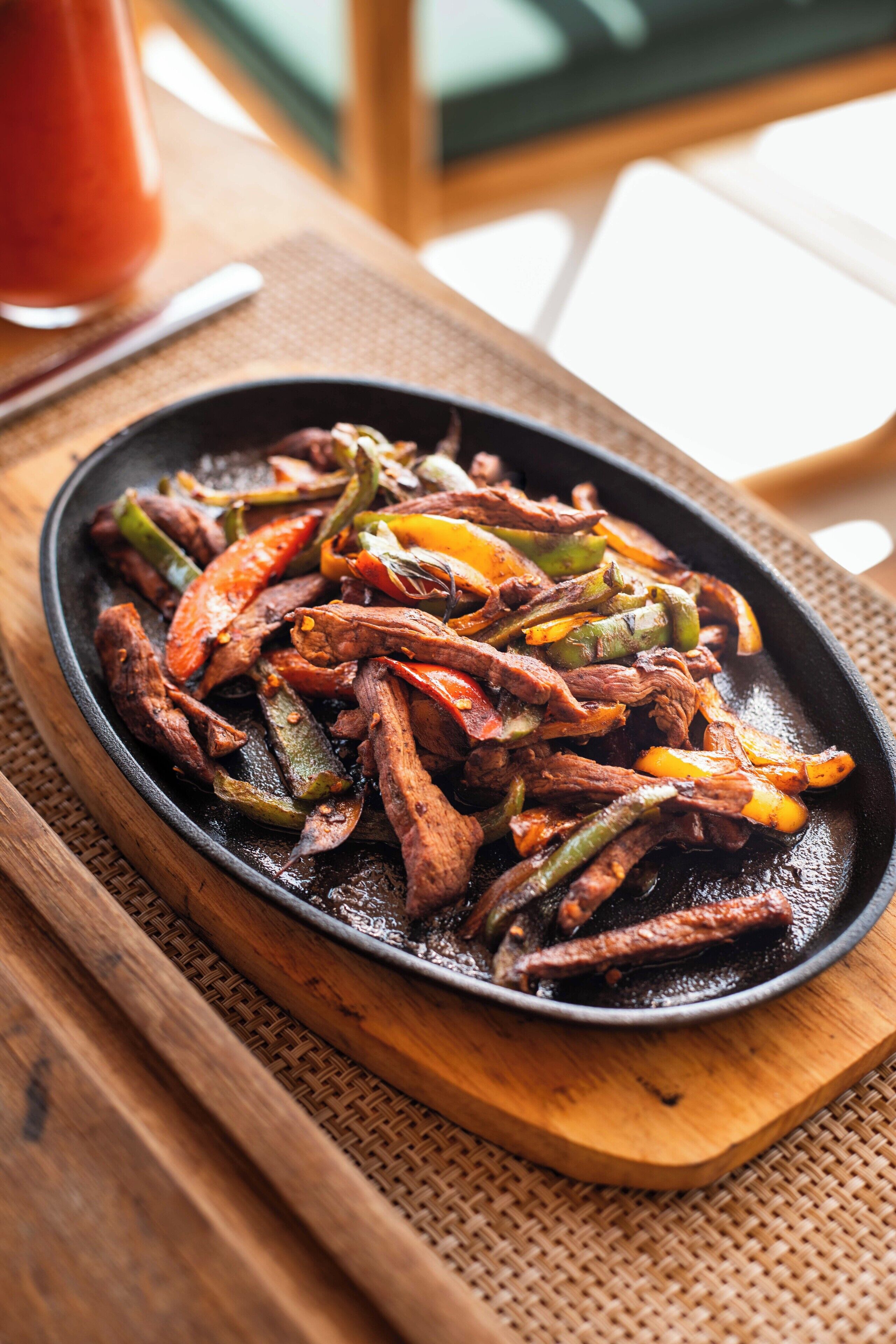 A plate of stir-fried beef and vegetables on a wooden board.