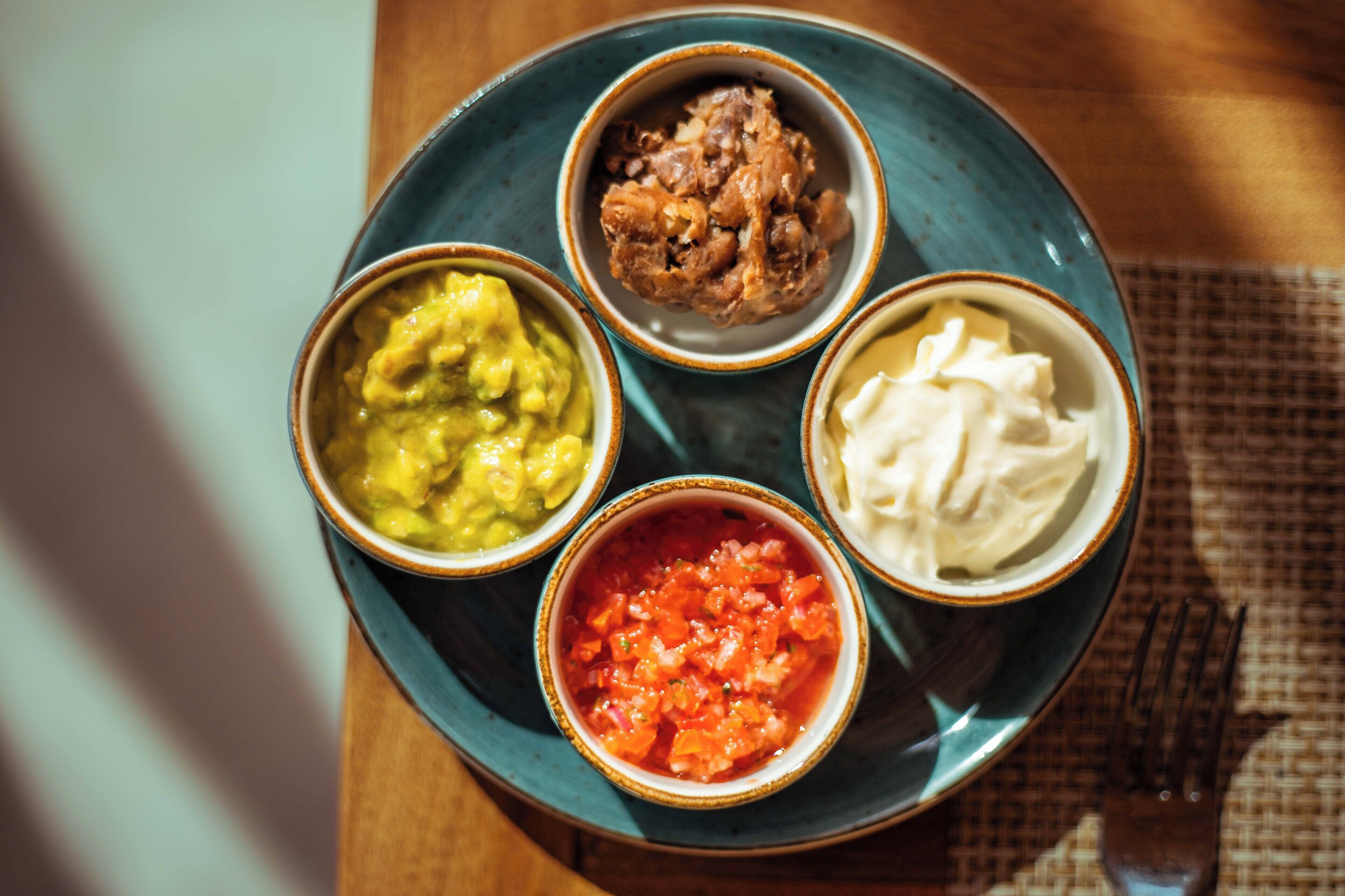 A table with four bowls of different food items.