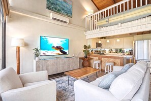 A modern living room with a flat-screen TV, a wooden coffee table, and a sofa.
