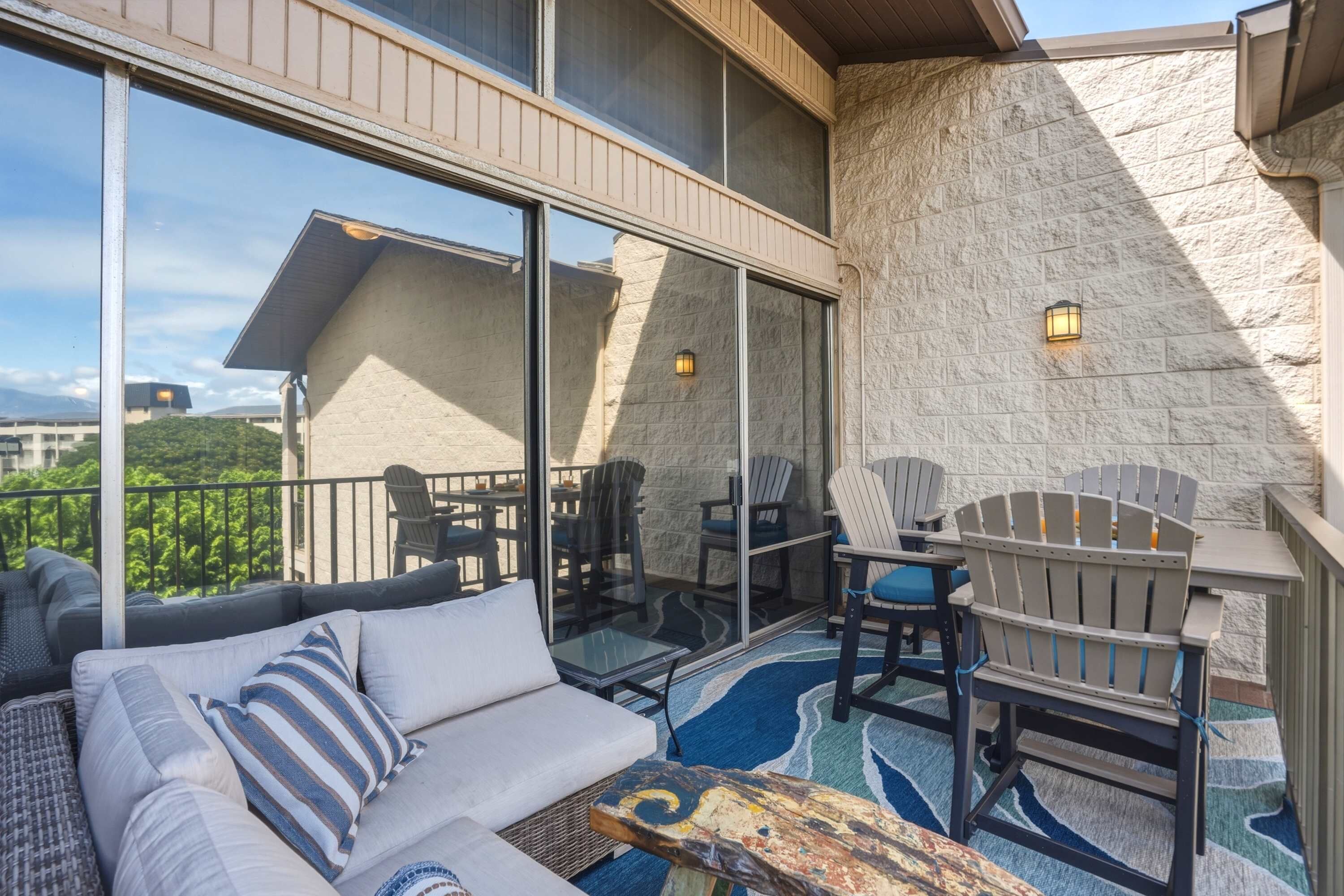 A balcony with a sofa, chairs, and a table.
