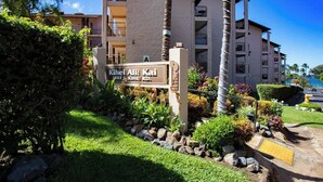 A multi-story building with a sign indicating 'Kihei Ali Kai 2387 S. KIHEI RD.'