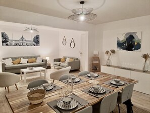 Una sala de estar moderna con comedor, que incluye un conjunto de sofá, una mesa de centro y un juego de mesa para seis personas.
