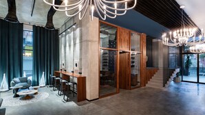 A modern interior with a bar area, seating, and a staircase. - STEPS Batumi  Hotel & Suites (Batumi)