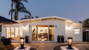 Une maison moderne dotée d’un patio, de portes-fenêtres coulissantes et du numéro 3900 inscrit sur le toit.