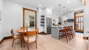 A modern kitchen with white cabinets, stainless steel appliances, and wooden flooring. - Historic Whittier Neighborhood - Near City Park & Golf - Fenced Yard (Denver)