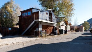 Ein rustikales Gebäude mit Holzfassade, einem Metallbalkon und einer Garage.