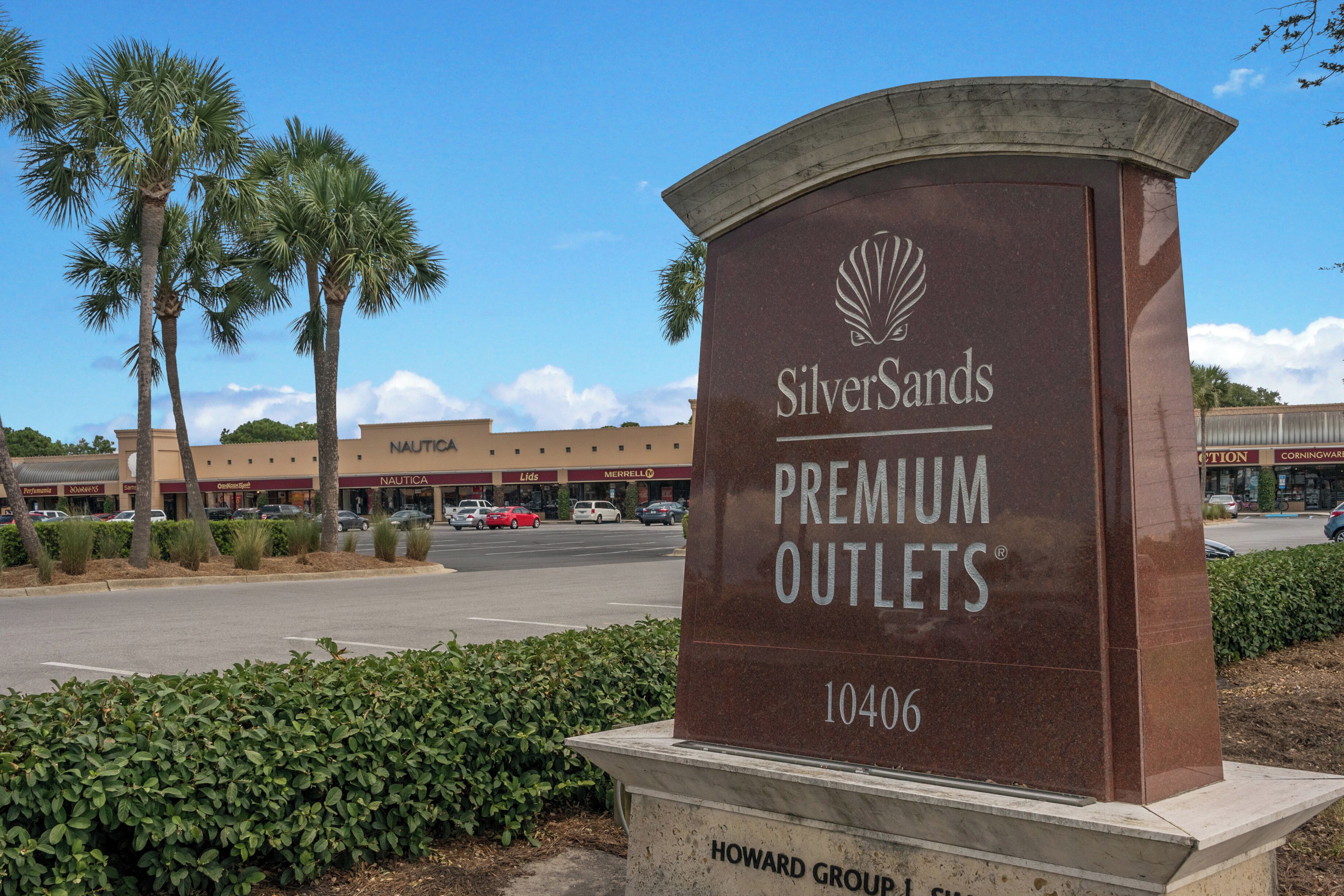 A sign for SilverSands Premium Outlets with a clear view of the surrounding parking lot and nearby buildings.