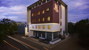 A modern hotel with a prominent 'Merryvale City Hotel' sign, multiple windows, and a well-lit entrance.