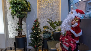 A lobby with a small Christmas tree, a potted plant, and a Santa Claus decoration. - Stay Suite Hotel (Eyup)