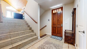 A staircase leading to a wooden door with a small rug at the bottom. - Mammoth Gateway Village #6 3 Bedroom Condo by RedAwning (Mammoth Lakes)