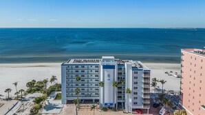 A beachfront hotel with multiple floors, a pool area, and a view of the ocean. - Beach Villas # 506-250 Estero Blvd 2 Bedroom Apts by RedAwning (Fort Myers Beach)