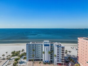 Un hôtel situé en bord de mer, avec plusieurs étages, une piscine et une vue sur l’océan.