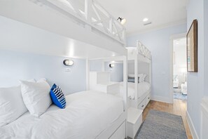 Cozy retreat with a bunk bed, reading lights, and a framed picture on the wall.