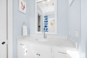 Bathroom features a sink, mirror, and shower.