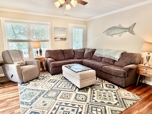 A living room with a sectional sofa, a chair, a coffee table, and a rug.