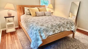 Una camera da letto con un letto, due comodini, un tavolino e uno specchio.