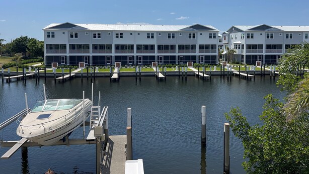 A waterfront hotel with a dock and a boat. - Stunning Waterfront 2-bdrm condo with Executive Office & Boat Lift (Punta Gorda)