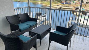 A balcony with wicker furniture and a view of a body of water. - Stunning Waterfront 2-bdrm condo with Executive Office & Boat Lift (Punta Gorda)