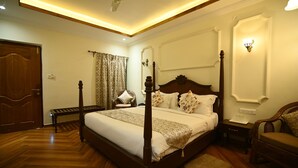 A four-poster bed with a wooden frame, a bedside table, a chair, and a nightstand. - Rosewood Resort (Bichhiya)