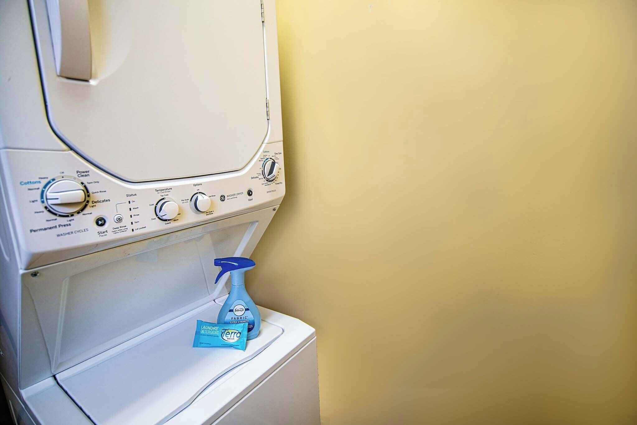 Una lavadora de carga frontal con mandos y paquetes de detergente.
