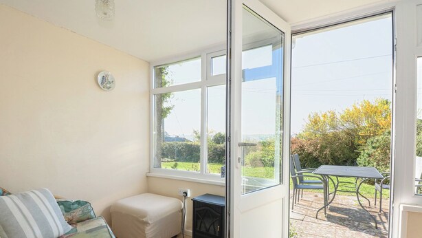 Une chambre avec un lit, une petite table et une fenêtre donnant sur le jardin.