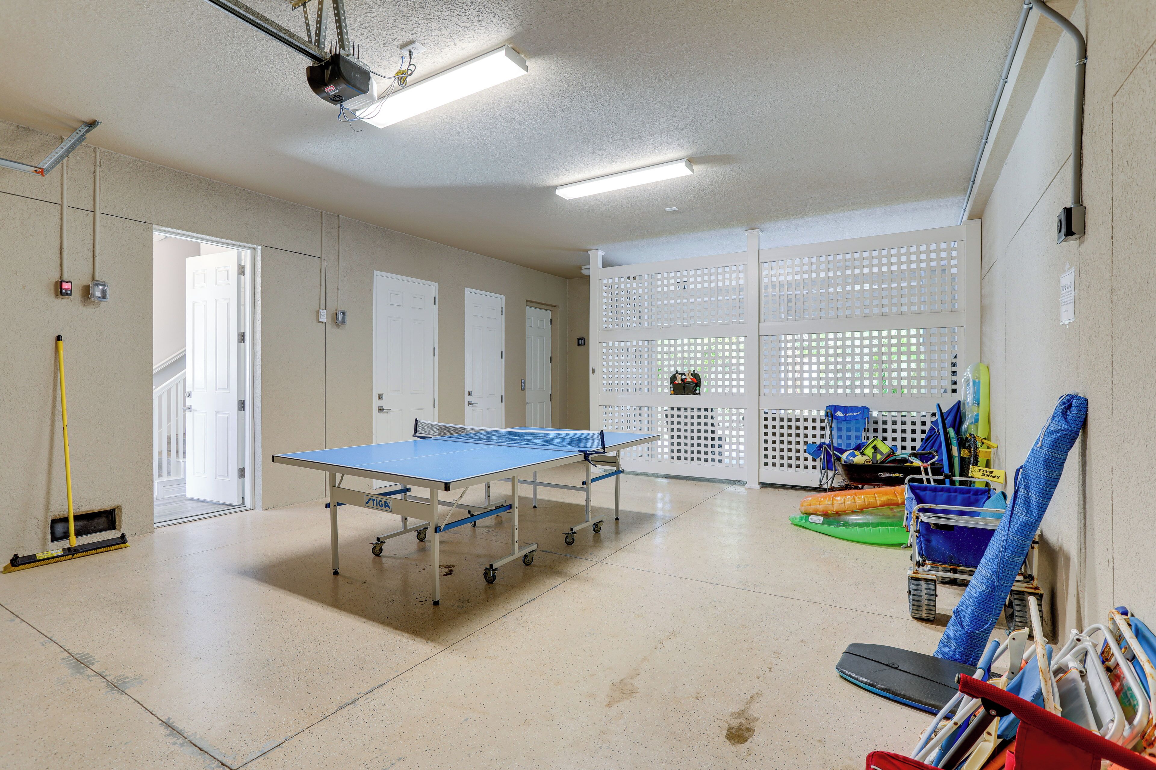 Habitación amplia con mesa de ping pong, un trapeador y productos de limpieza.