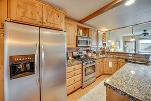 A kitchen with wooden cabinets, stainless steel appliances, granite countertops, and a built-in oven. - 6 Mi to Winter Park Resort: Townhome w/ Hot Tub! (Fraser)
