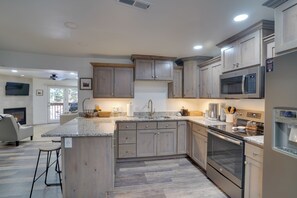 A modern kitchen with wooden cabinets, stainless steel appliances, and a granite countertop. - Brian Head Condo w/ Balcony, Grill & Mountain View (Brian Head)