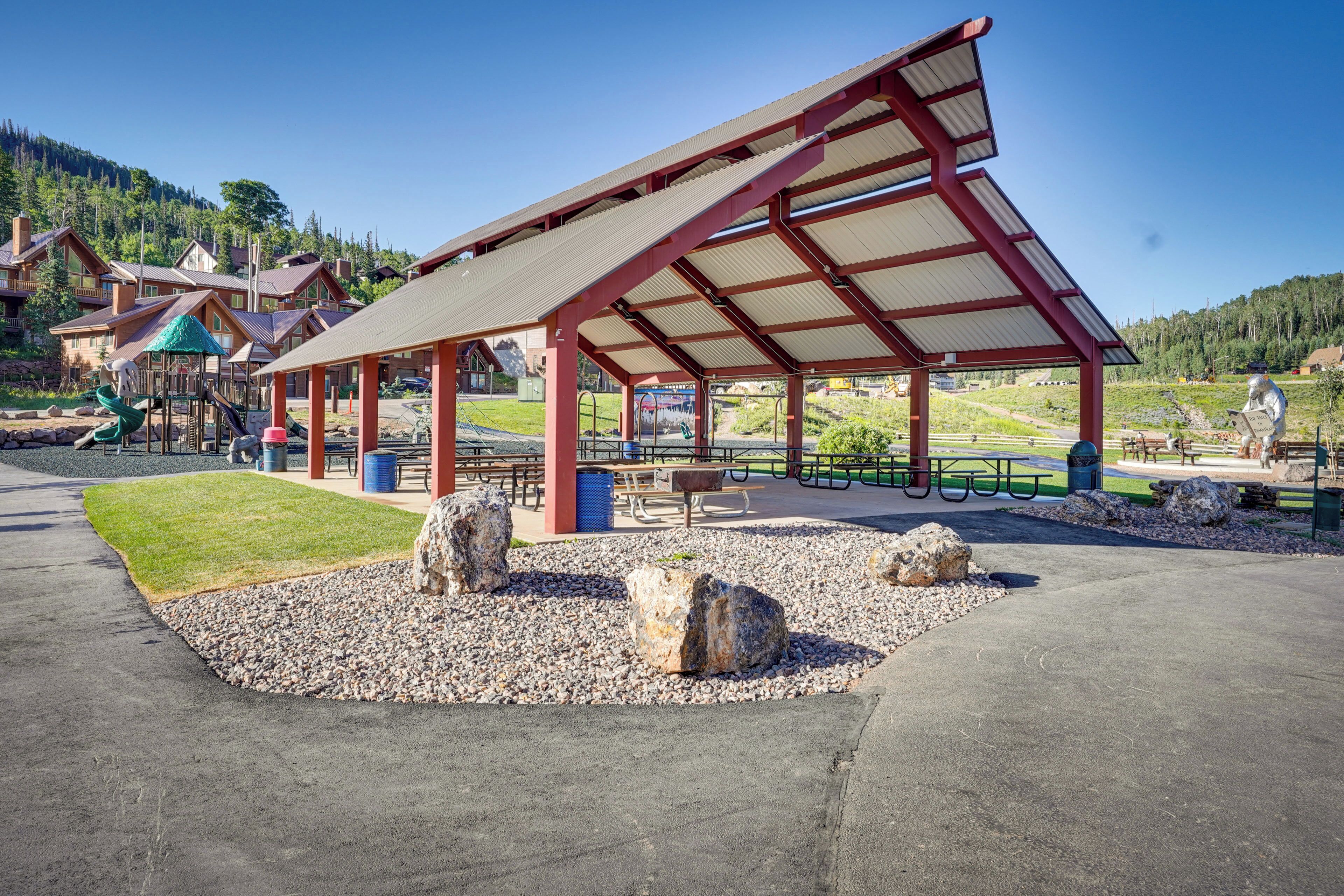 A covered pavilion with picnic tables and a playground.