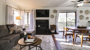Una sala de estar con chimenea, sofá, mesa de centro y comedor.