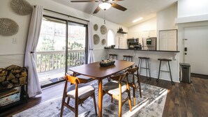 Una cocina moderna con comedor, ventilador de techo y vistas al exterior.