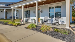 A covered porch with outdoor seating, a stop sign, and a well-maintained garden area. - Lake Access & Boat Slip: Greenwood Cottage! (Greenwood)
