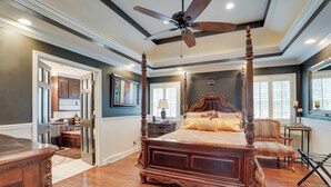 A four-poster bed with a wooden finish, a ceiling fan, and a view of the adjacent kitchen. - Moncks Corner Home ~ 4 Mi to Lake Moultrie! (Moncks Corner)