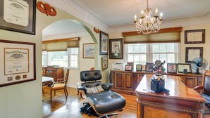 A spacious office with a large desk, leather chairs, framed certificates, and a chandelier. - Moncks Corner Home ~ 4 Mi to Lake Moultrie! (Moncks Corner)