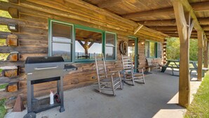A rustic wooden cabin with a covered patio, a barbecue grill, rocking chairs, and a picnic table. - Remote Escape: Vermont Cabin w/ Mountaintop Views! (Sharon)