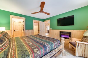Cozy retreat with a large bed, fireplace, and television.