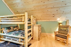 Cozy room with a bunk bed, wooden bench, and small cabinet, perfect for a relaxing stay.
