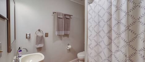 Ein Badezimmer mit Waschbecken, Toilette und Duschvorhang.