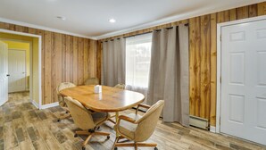 Un salón de conferencias con una mesa de madera, cuatro sillas y una puerta blanca.