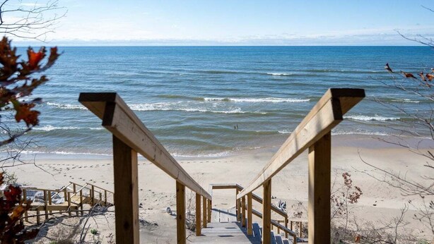 A wooden staircase leading to a beach with a view of the ocean. - Beautiful Lake Michigan Home Great for Large (West Olive)