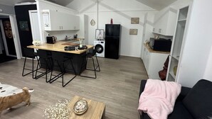 Un espacio habitable compacto con cocina, comedor y sofá.