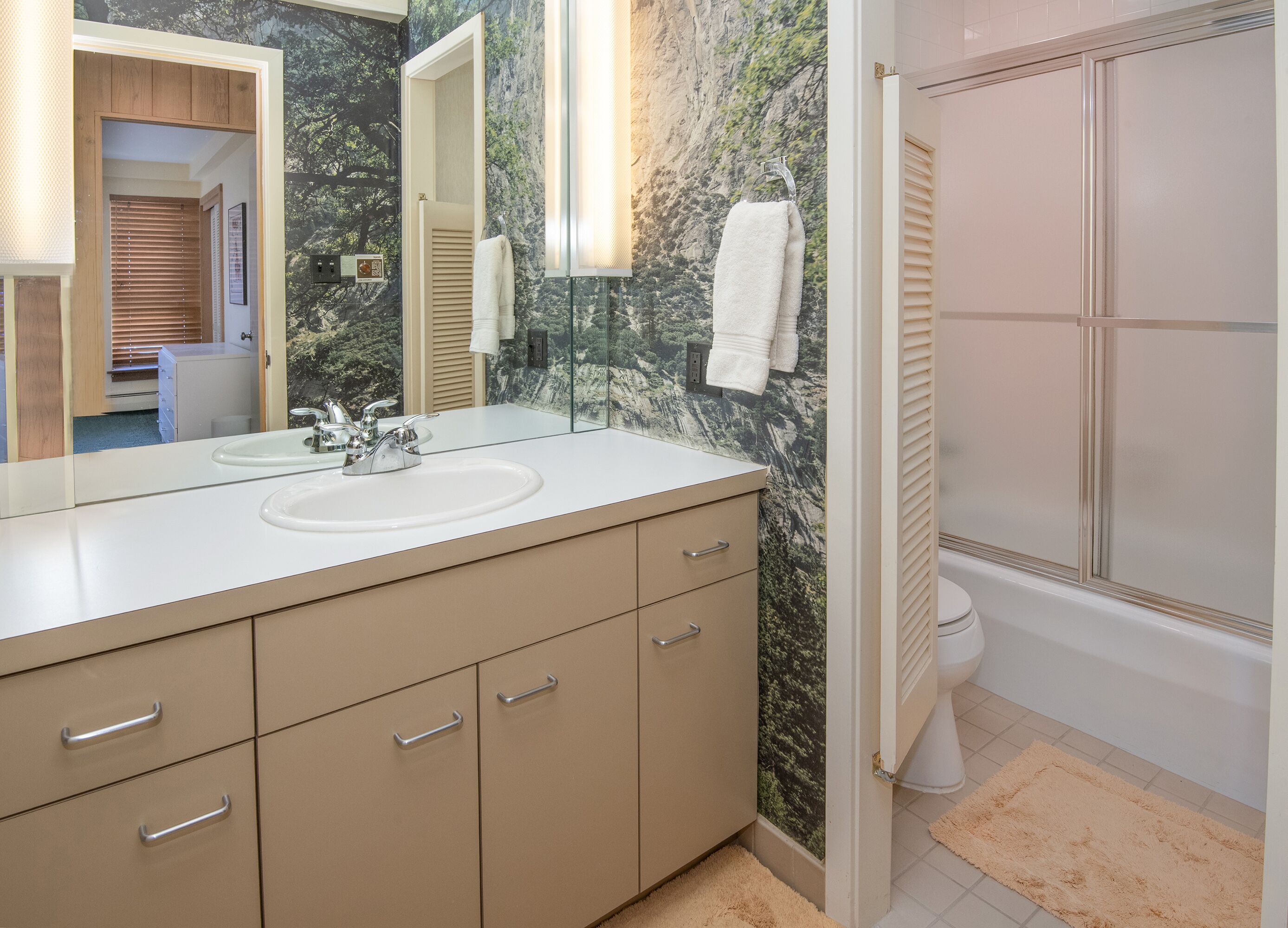 A bathroom with a sink, mirror, and towel rack.