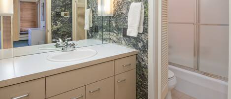 A bathroom with a sink, mirror, and towel rack.